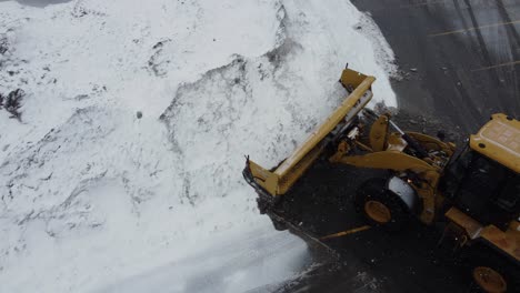 Snow-removal-machine-clearing-the-parking-lot-from-the-snow-in-winter