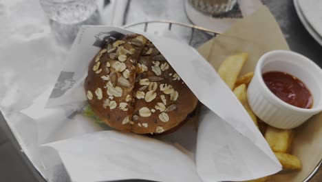 Brunch-set-of-fruit-juice,-burger-and-french-fries-with-catchup-on-a-table-in-a-cafe