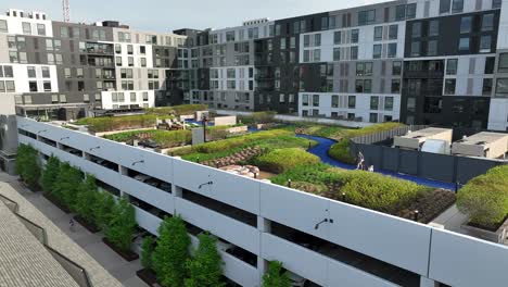 Dog-park,-rooftop-garden,-and-outdoor-seating-on-top-of-parking-garage-outside-modern-apartment-complex-in-urban-American-city