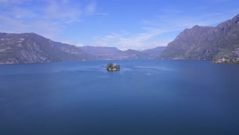 Drone-approaching-from-distant-to-Loreto-small-and-tiny-island-in-Iseo-lake