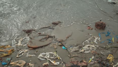 Noch-Eine-Aufnahme-Von-Müll-Und-Gebrauchten-Plastiktüten-Im-Sand-An-Einem-Flussufer