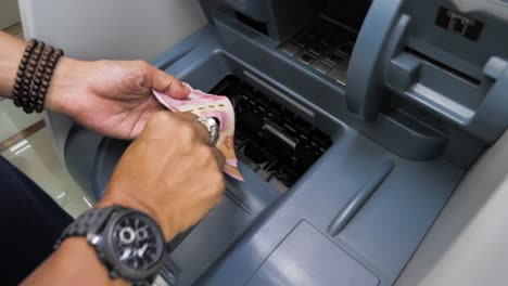 Primer-Plano-Del-Cajero-Automático,-Esta-Persona-Recibe-Dinero-En-Efectivo-En-Rupias-Del-Cajero-Automático,-Billetes-Indonesios-En-Rupias,-La-Moneda-Local-De-Indonesia,-Filmados-En-Cámara-Lenta