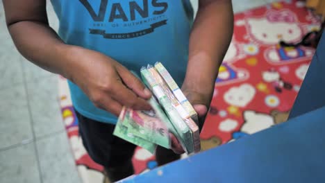 man-is-holding-and-counting-stacks-of-money,-rupiah,-Indonesian-currency