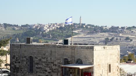 Israel's-flag-flutters-in-the-wind-in-front-of-the-holy-Wailing-Wall,-one-of-the-most-sacred-places-to-the-Jewish-people