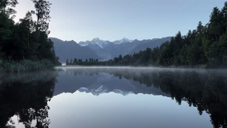 Serene-sunrise-at-Lake-Matheson-with-perfect-reflection-of-snowy-mountain-peaks