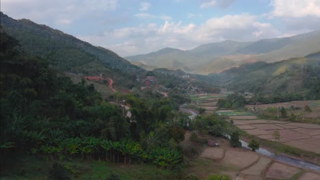 Young-Man-Flying-Drone-From-Cottage-Huts-In-Spectacular-Green-Landscape-Of-Sapan