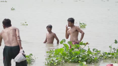 Poor-Indian-people-bathing-in-river-bank-of-Ganga-in-summer,-Rani-Rashmoni-ghat,-slow-motion