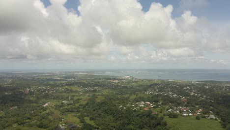 aerial-view-in-Guadeloupe,-showing-small-villages-and-the-sea-in-the-distance