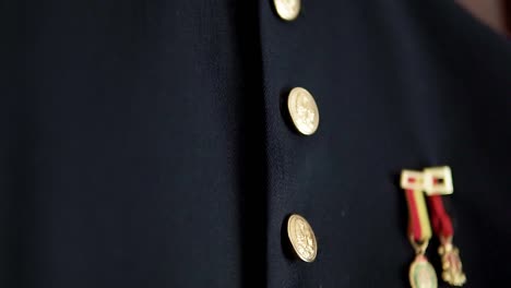 Slow-tilting-shot-of-a-military-outfit-with-golden-pins-hanging-for-a-wedding