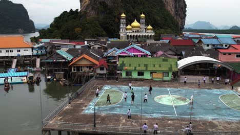 Un-Dron-Disparó-Hacia-Personas-Jugando-Al-Fútbol-En-El-Pueblo-Pesquero-Flotante-De-Ko-Panyi,-En-La-Nublada-Tailandia.