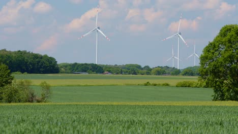 Beautiful-serene-countryside-with-farm-field-and-wind-turbines-park,-energy
