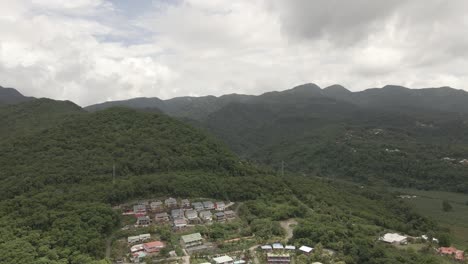 Drone-view-of-a-village-surrounded-by-tropical-forest-in-Guadeloupe