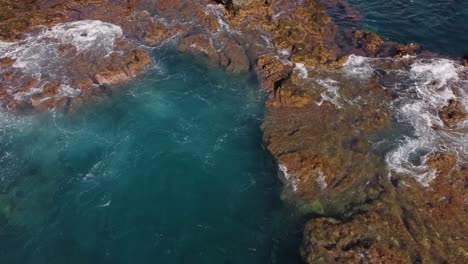 Deep-coastal-water-with-rocky-cliff-near-Tenerife,-aerial-drone-view