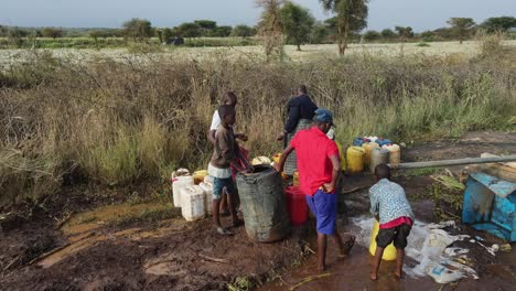 El-Pueblo-Masai-Llena-Jarras-De-Plástico-Con-Agua-Potable-Del-Pozo,-Loitokitok,-Kenia