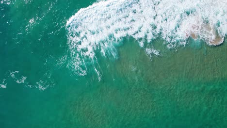 Bright-green-blue-ocean-topview-of-waves-washing-upon-shore-from-ocean-sea-waters