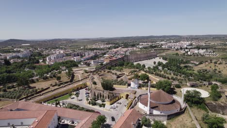 Aerial-View-Over-Our-Lady-Of-Conception-Church-In-Elvas-With-Amoreira-Aqueduct-In-Background