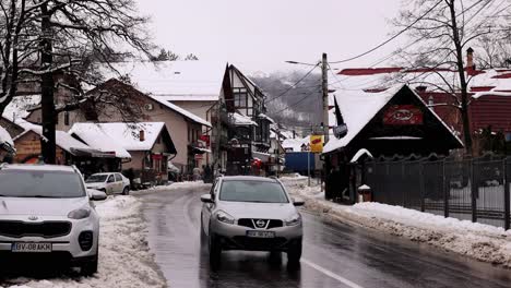 Carretera-Asfaltada-Mojada-En-El-Pueblo-Invernal-De-Bran-En-El-Condado-De-Brașov,-Transilvania,-Rumania