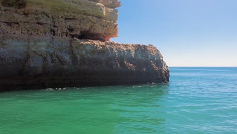 From-a-Boat-a-4K-reveal-shot-of-the-Portugal-Algarve-Coast-Caves-and-Cliffs-Looking-west-towards-Vilamoura