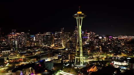 Establishing-aerial-of-Space-Needle-over-illuminated-city-in-Seattle-at-night