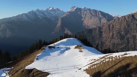 Drohnenclip-Bewegt-Sich-In-Richtung-Berge-Mit-Schneebedecktem-Vordergrund-Und-Kiefernwald