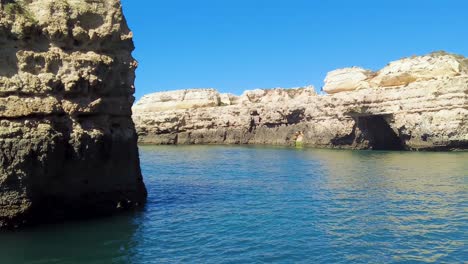 Eine-4K-Aufnahme-Der-Sandsteinhöhlen-Und-Klippen-An-Der-Küste-Der-Algarve-In-Portugal