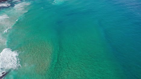Klares-Meerwasser-Von-Oben,-3D-Bewegungsdrohnen-Luftübersicht-über-Meereswellen,-Die-Zum-Ufer-Strömen