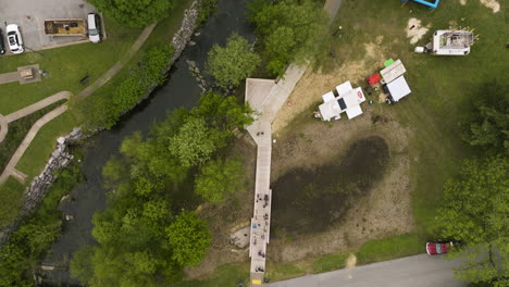 Aerial-View-Of-People-Walking-On-Promenade-Near-Sager-Creek-In-Downtown-Siloam-Springs