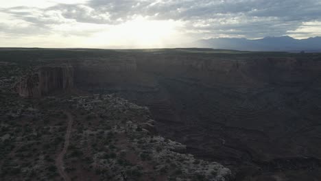 Trail-in-desolate-canyon-landscape,-sweeping-aerial