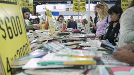Low-angle-static-view-of-books-out-of-focus-in-foreground-of-bookfair-and-people