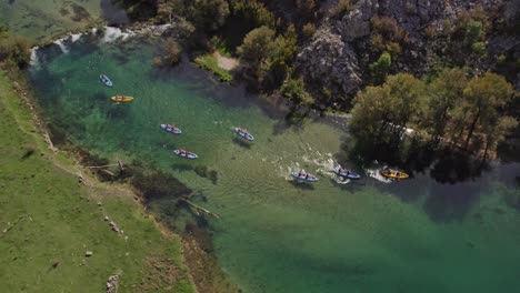 Kayaks-on-clear-blue-water-at-zrmanja-river-Croatia-during-summer,-aerial,-top-down