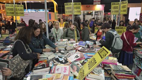 Stand-De-Descuento-Especial-De-Libros-Baratos-En-Una-Mesa-Desordenada-Y-Llena-De-Gente-En-La-Feria