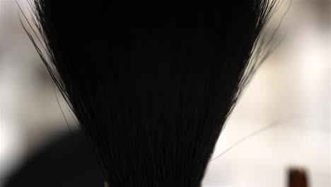 Pan-up-along-black-paintbrush-with-wide-rounded-head