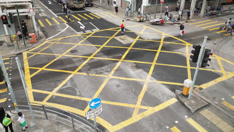 Blick-Aus-Einem-Hohen-Winkel-Auf-Die-Kreuzung-In-Hongkong,-Während-Arbeiter-Und-Menschen-Die-Kreuzung-überqueren