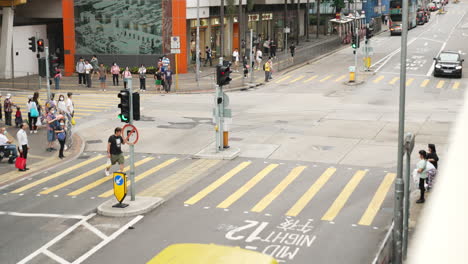 People-waiting-at-crosswalk-while-there-is-no-traffic-present-in-hong-kong-asia