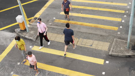 Bird's-eye-view-of-people-crossing-crosswalk-in-asia,-hong-kong