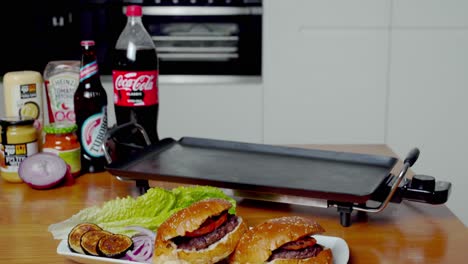 Tiro-Inclinado-Hacia-Arriba-Que-Revela-Deliciosas-Hamburguesas-En-Un-Plato,-Plancha-Al-Fondo