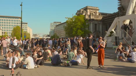 La-Gente-Se-Para-Y-Se-Sienta-En-El-Suelo-Bajo-El-Sol-Durante-El-Evento-Piknik-Elektronik-En-La-Plaza-De-Poelaert,-Bruselas,-Bélgica