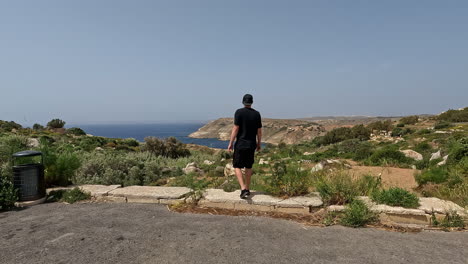 Turista-Masculino-Caminando-Por-La-Costa-Occidental-De-La-Isla-Maltesa-En-Verano