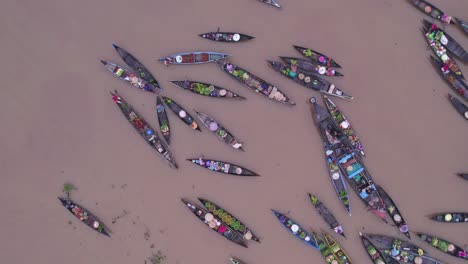 Top-down-of-slow-moving-wooden-boats-full-of-food-at-Lok-baintan-floating-market,-aerial