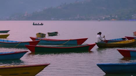 Nepalese-person-slowly-paddling-boat-across-calm-pokhara-lakeside