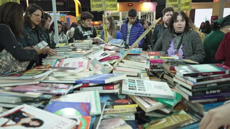 Jib-shot-descends-over-table-full-of-discounted-books-as-people-thumb-through-them