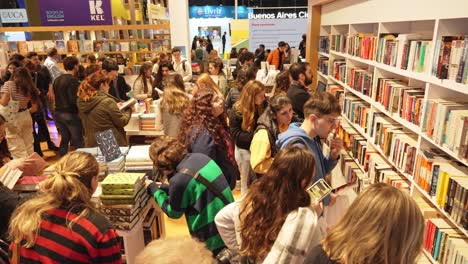 Pan-across-young-adults-looking-through-shelves-of-books-searching-for-a-good-read