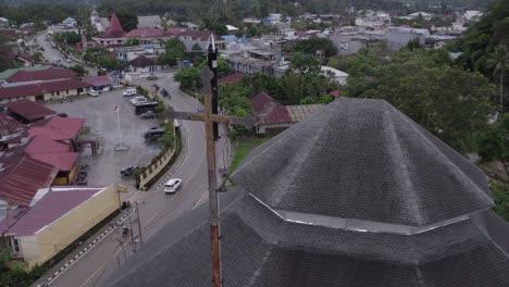 Close-up-of-cross-on-top-of-a-church-at-Waikaboebak-city,-aerial