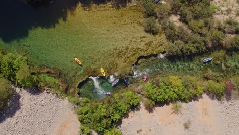 Top-down-shot-kayak-goes-down-small-waterfall-at-zrmanja-river-Croatia,-aerial