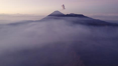 Reveal-shot-of-mount-bromo-national-park-with-low-clouds,-aerial
