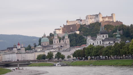A-wide-open-view-of-Fortress-Hohensalzburg,-Salzburg,-Austria-in-the-morning-when-the-sunlight-falls-into-the-top-of-the-castle-with-a-clear-sky-in-the-background