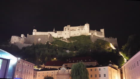 A-wide-open-view-of-Fortress-Hohensalzburg,-Salzburg,-Austria-at-night-when-the-artificial-lighting-falls-into-the-top-of-the-castle-with-a-dark-sky-in-the-background