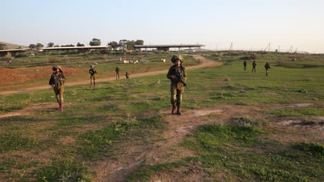 Soldiers-with-guns-walking-on-grass-field-in-formation