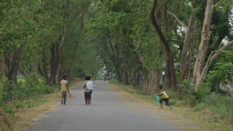 Bangladeschische-Arme-Dorfjungen,-Die-Auf-Der-Straße-Spazieren-–-Blick-Auf-Das-Dorf-Am-Straßenrand,-Ländliches-Bangladesch