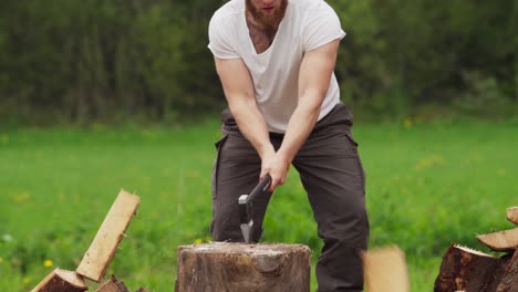 Man-Chopping-Logs-With-An-Axe-On-Chopping-Block---close-up